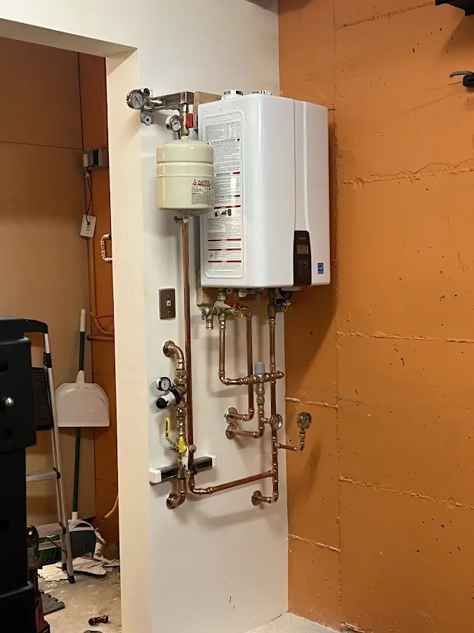 Plumbing technician inspecting water heater connections in Navasota